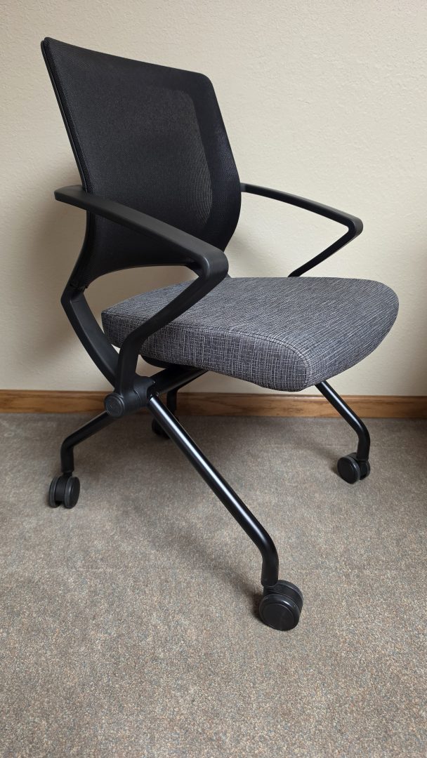 A mobile training room chair shown with the seat flipped down.